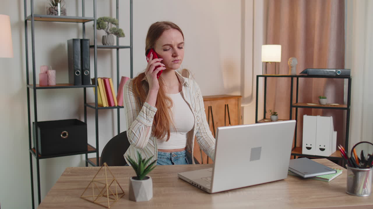 Ung kvinde bruger sin bærbare computer, mens hun sidder i sofaen og arbejder eller shopper online hjemmefra.