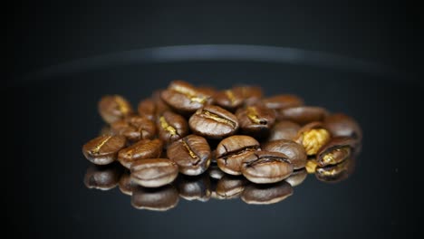 dark coffee beans with reflection on surface