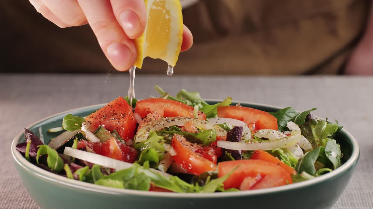 Preparing a fresh vegetable salad with lemon dressing