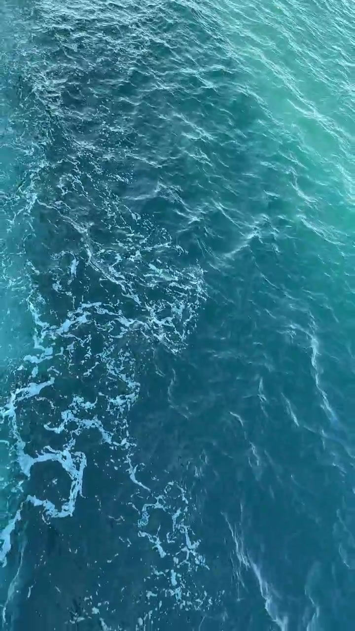 Acqua dell'oceano turchese con onde dolci e schiuma
