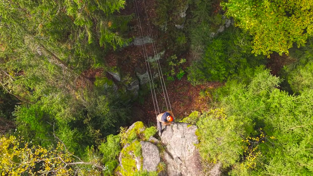 High aerial view of person walk between cliffs using metal cable path, Czechia