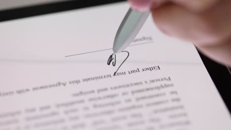 stylus writing signature on digital tablet closeup