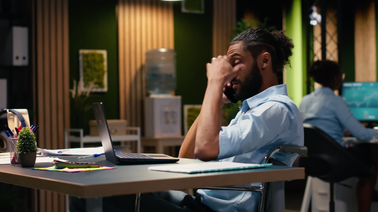 Arab businessman in wheelchair answering telephone call on smartphone