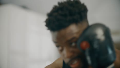 cu of boxers face whilst punching bag