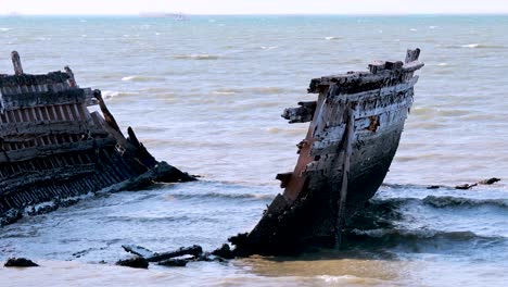 waves crash against a decaying shipwreck