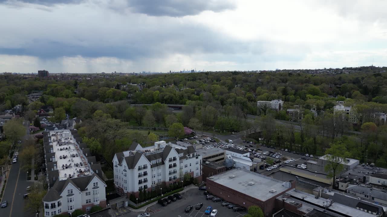 Horizontal drone footage featuring a pull-away shot from Bronxville, New York. Captures the suburban landscape and tree-lined streets, ideal for real estate, cityscape, or landscape visuals.