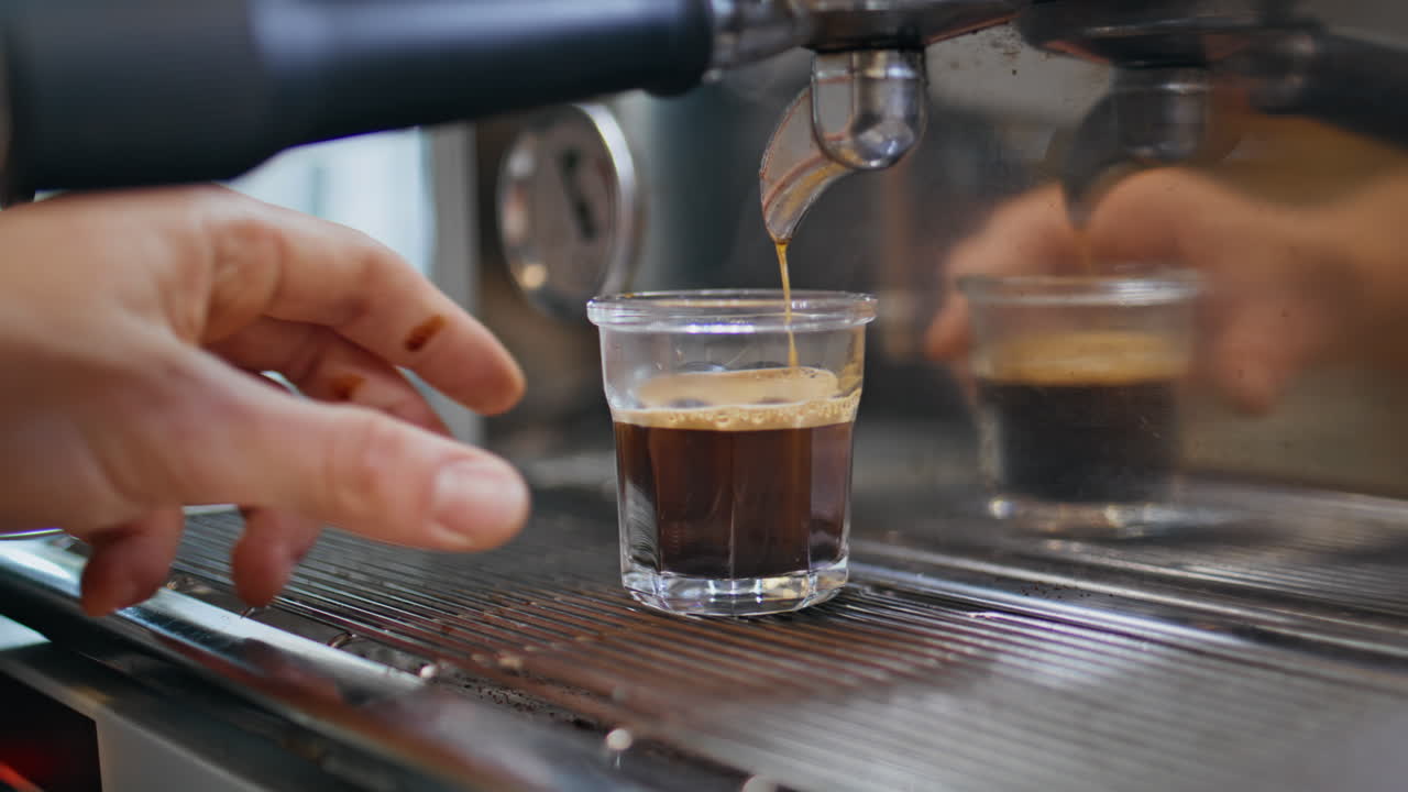 Barista hand made espresso at bar counter closeup. Bartender making hot coffee