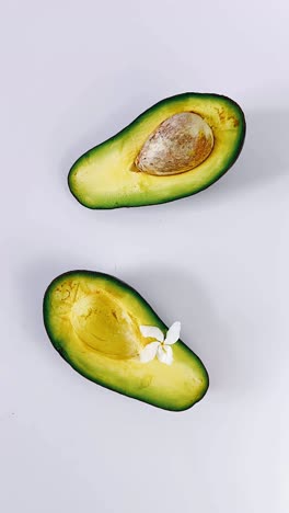 two halved avocados with white flowers