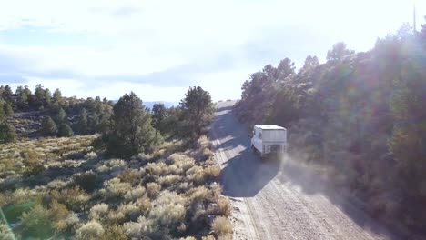 Car-dustclouds,-gravel-road,-sierra-desert