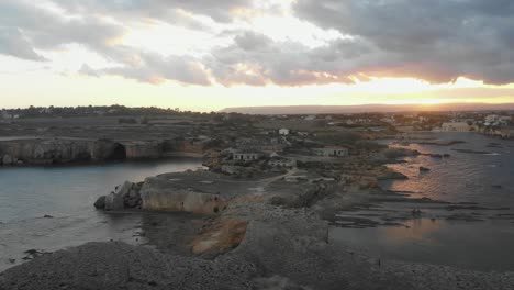 Rückwärtsflug-An-Den-Alten-Ruinen-Von-Punta-Della-Mola-Mit-Magischem-Sonnenuntergang,-Luftaufnahme