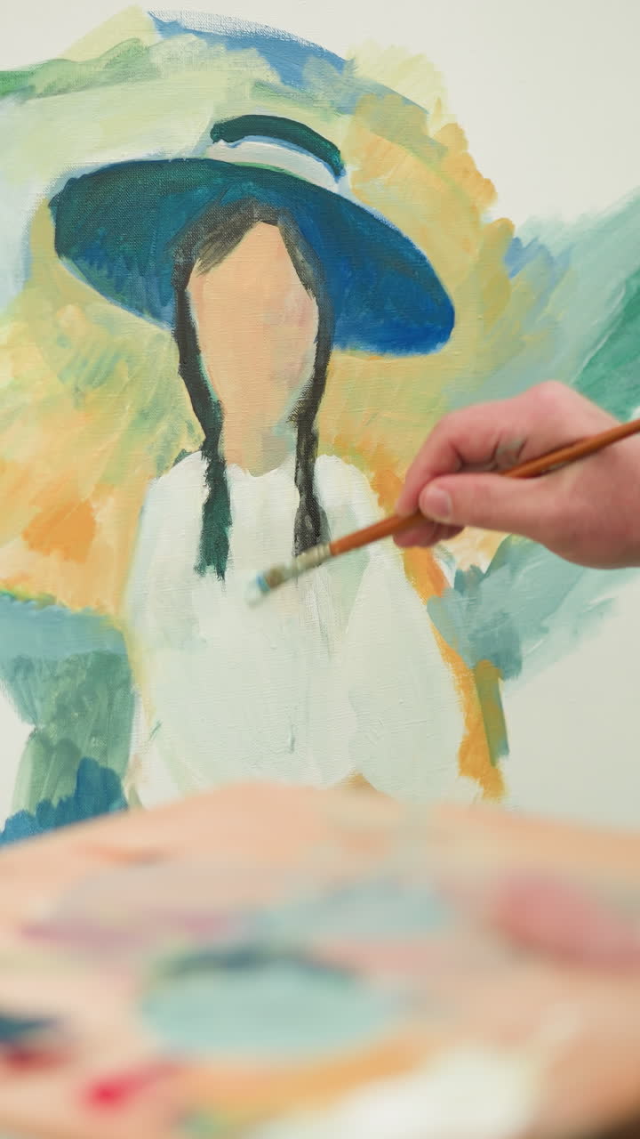 primer plano de un artista con un sombrero y una camisa a cuadros sosteniendo una paleta y pintando un retrato colorido en un lienzo. el enfoque está en la mano y el pincel mientras el artista da vida a la obra de arte al aire libre
