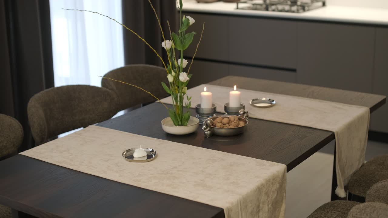 Elegant Dining Table Setting with Lit Candles and Floral Decor