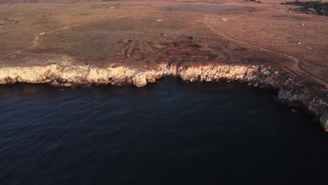 無人機從上向下觀看海浪在岩石海岸的噴射,背景