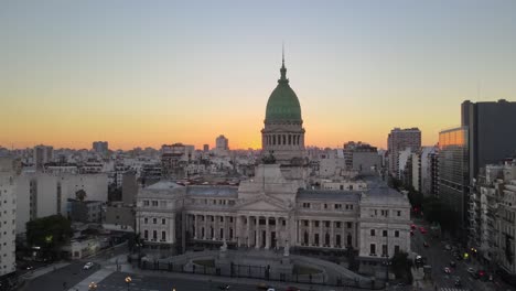 Aerial-rising-over-Argentine-Congress-Palace-with-Balvanera-buildings-in-background-at-golden-hour-in-busy-Buenos-Aires