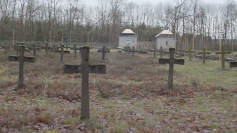 wide pan over old gravestones in weed overgrown graveyard