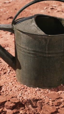 a rusty watering can on the ground