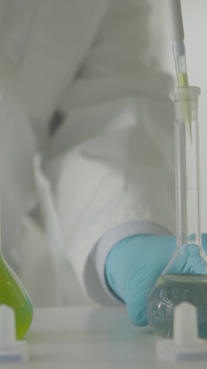 Scientist mixing chemicals in a lab, wearing blue gloves, focused experiment