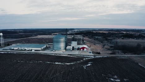 fotografía de un avión no tripulado de una granja rural rodeada de campos fangosos, lista para la siembra