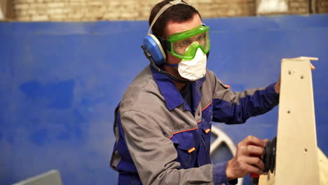 worker sanding wood in a workshop