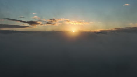 cinematic aerial drone shot above the clouds during sunset