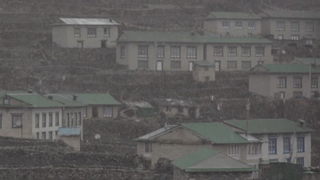 snow falls on a village in nepal