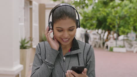 Retrato-De-Una-Hermosa-Mujer-De-Raza-Mixta-Disfrutando-Escuchando-Música-Usando-Audífonos-Enviando-Mensajes-De-Texto-Navegando-Usando-Tecnología-Móvil-De-Teléfono-Inteligente-En-La-Ciudad