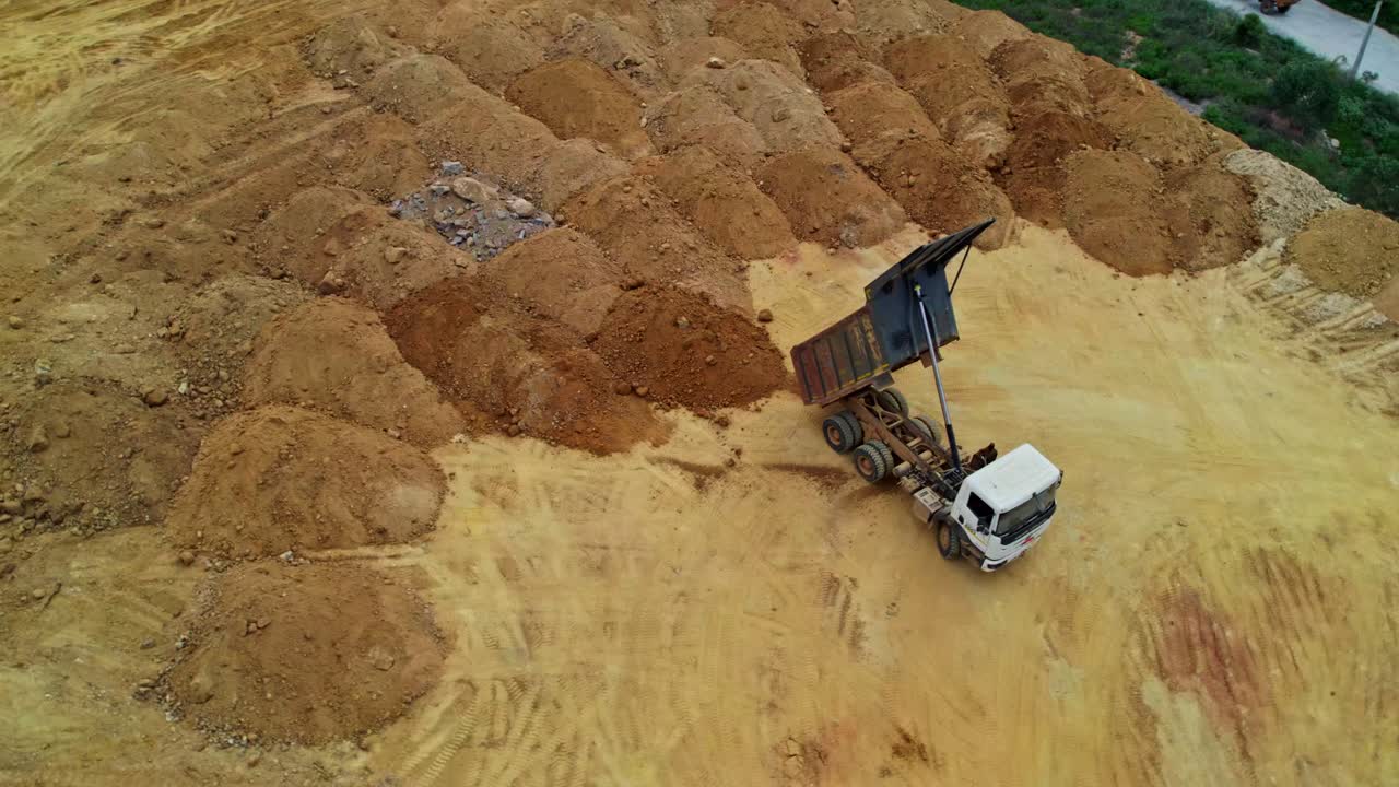 Top view of soil dump area with unloaded truck in telangana, india.
day time, semi orbit, drone shot, 4k.