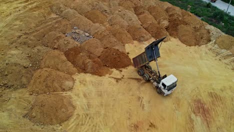 top view of soil dump area with unloaded truck in telangana, india.
day time, semi orbit, drone shot, 4k.