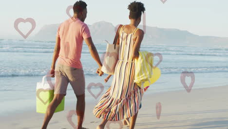 couple walking on beach holding hands with heart shapes overlay animation