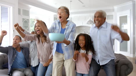 extended family group at home watching sports on tv