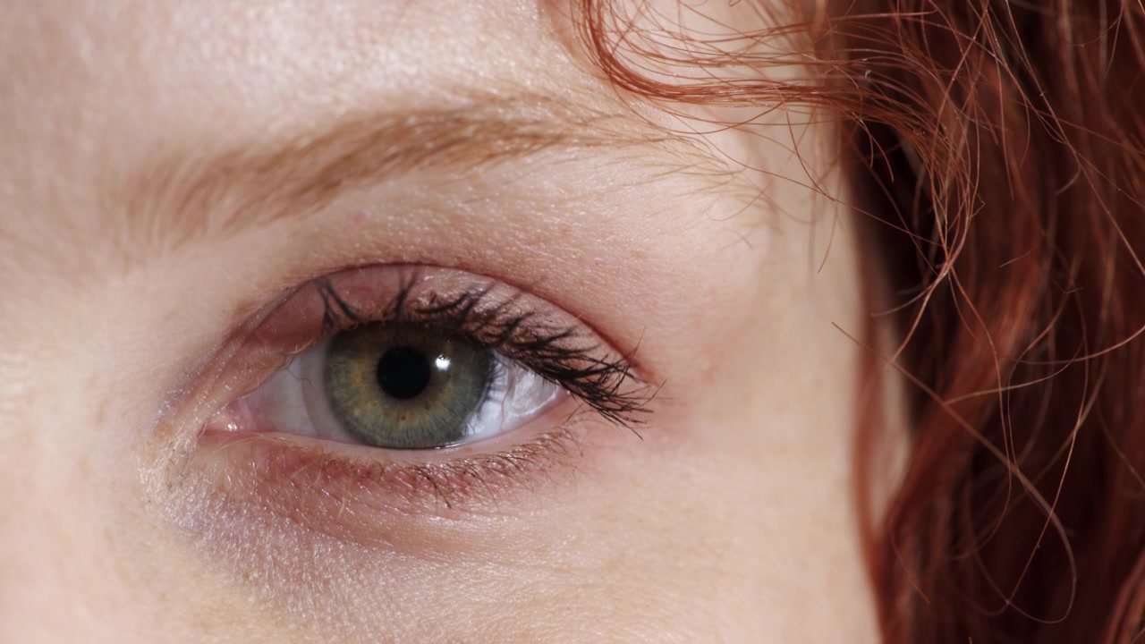 Primo piano di una donna che apre il suo occhio verde
