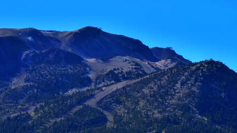 mammoth lakes mountain ski area aerial drone california mccoy station main lodge upper panorama gondola summer autumn fall sunny blue sky chairlift gondola ski trails snow cornice circle left