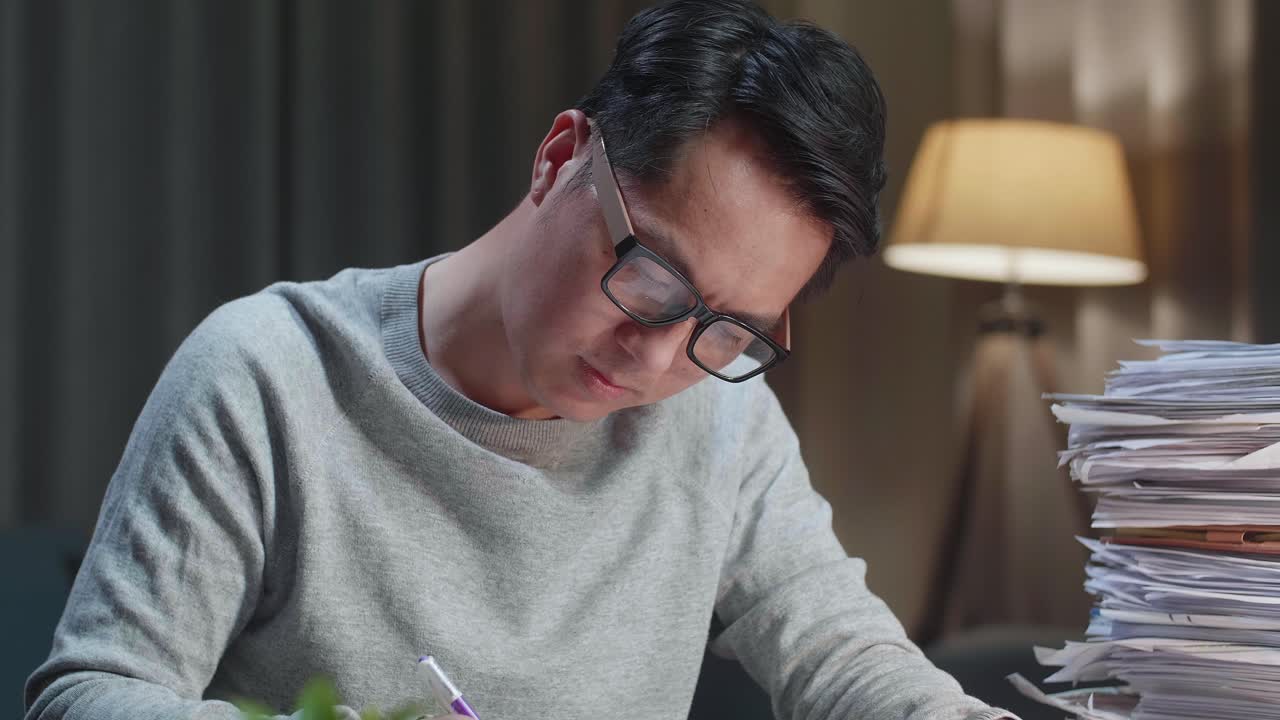 집에서 문서와 함께 일하는 아시아 남자의 클로즈업