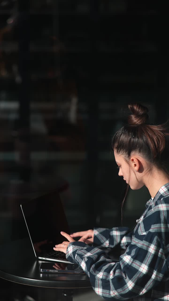 mujer trabajando en una computadora portátil en un café