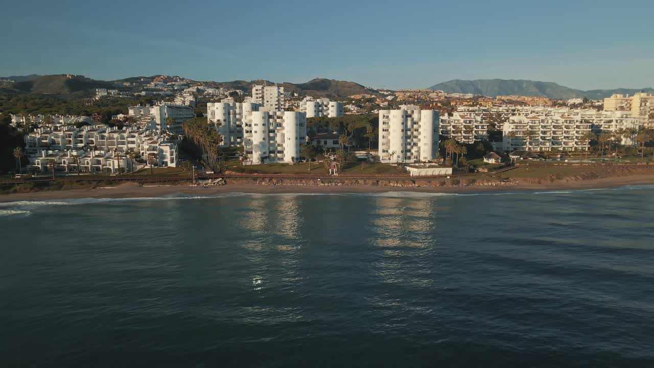 Vista aérea de playa y costa con alejamiento de cámara (dolly out)