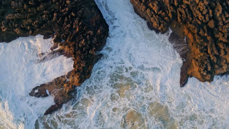 drone view stormy ocean waves breaking at volcanic coastal. closeup