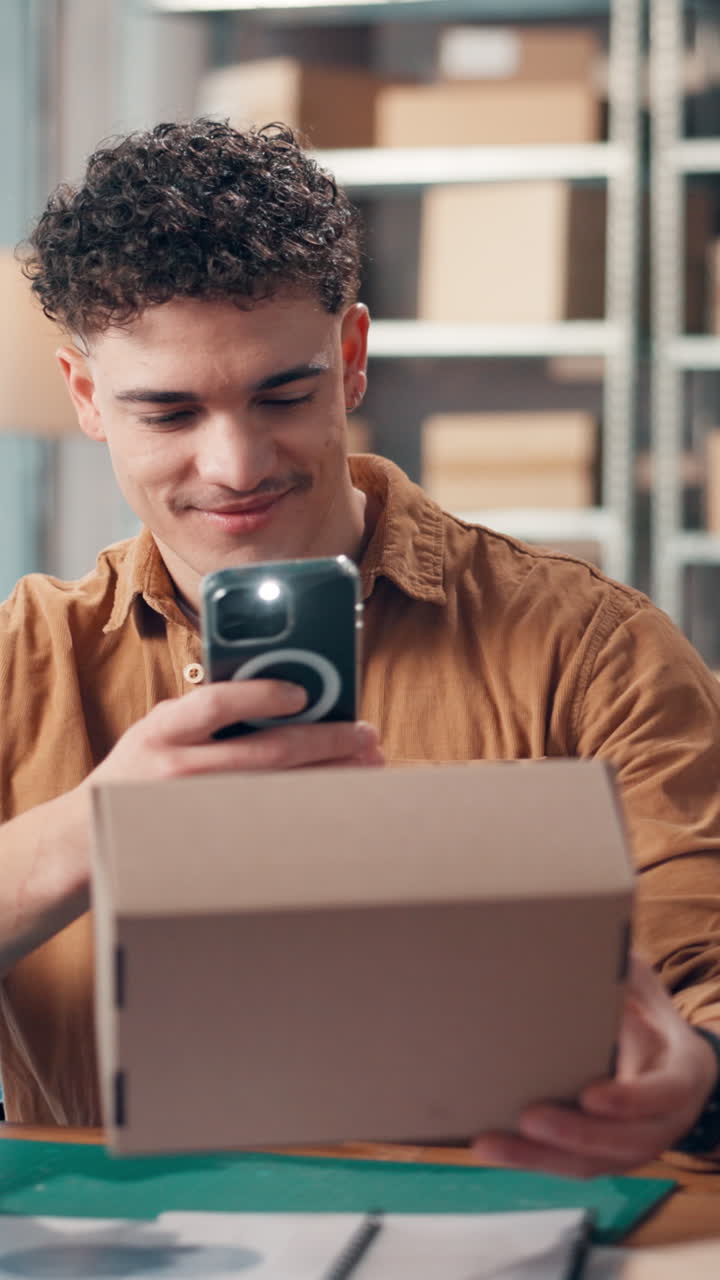 Joven escaneando una caja de cartón con un smartphone en un almacén