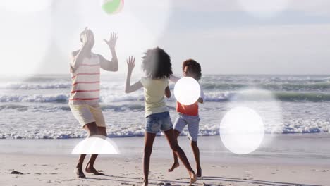 Animation-of-light-spots-over-african-american-family-at-beach