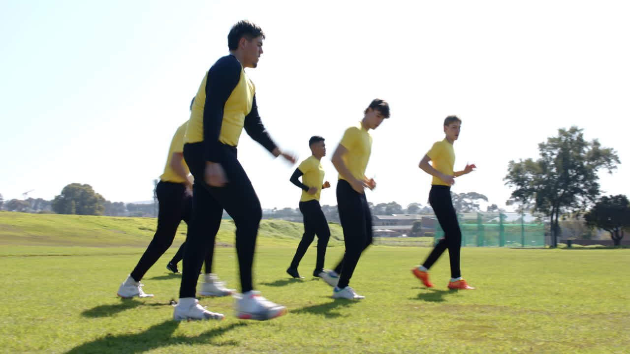 Running on field, cricket players in yellow shirts training for match