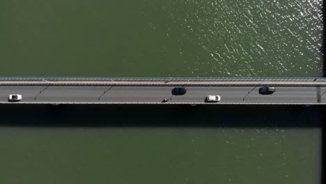 vertical aerial top view of car bridge with traffic passing by