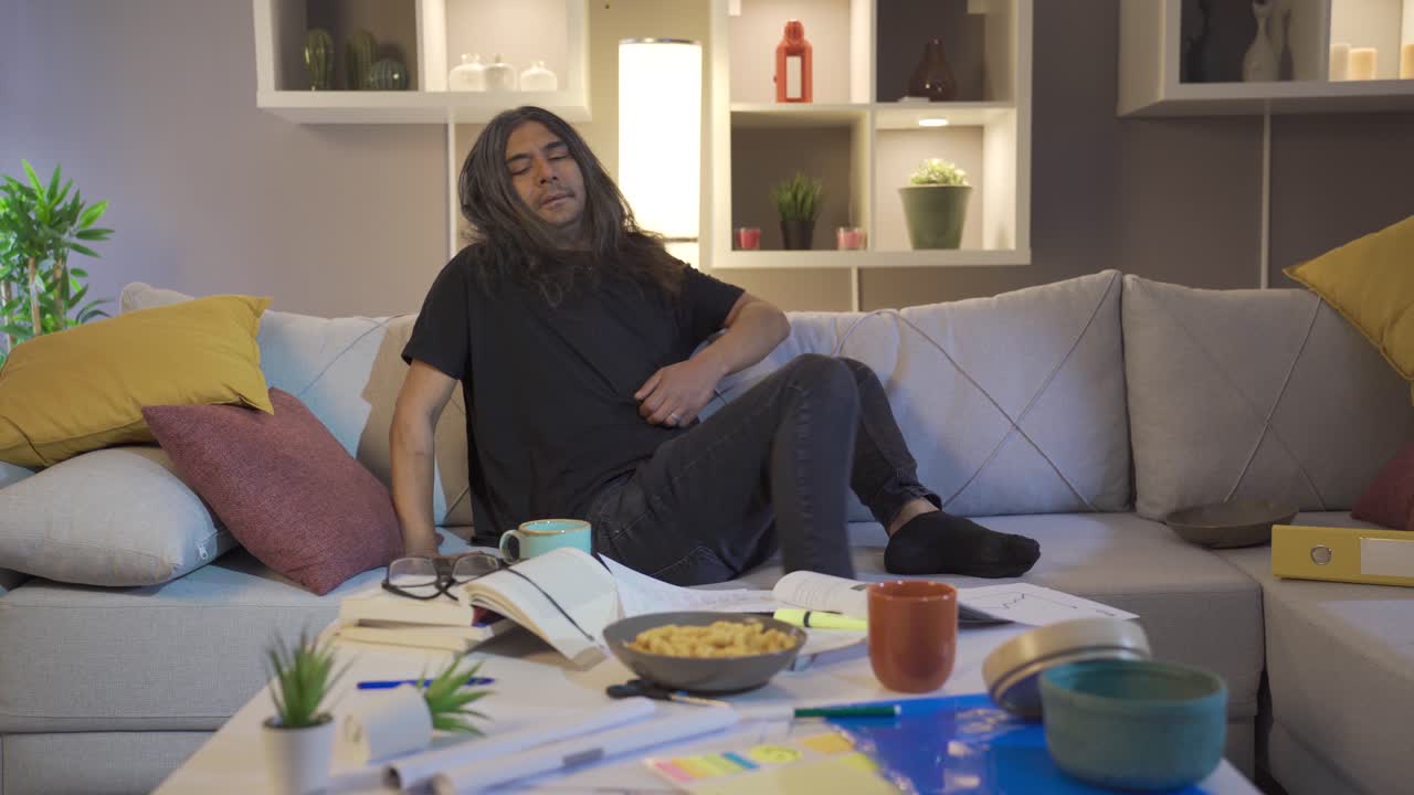 el hombre perezoso está sentado en el sofá.