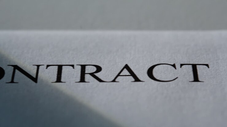 Primo piano di un contratto commerciale in controluce. Documento cartaceo con testo da firmare