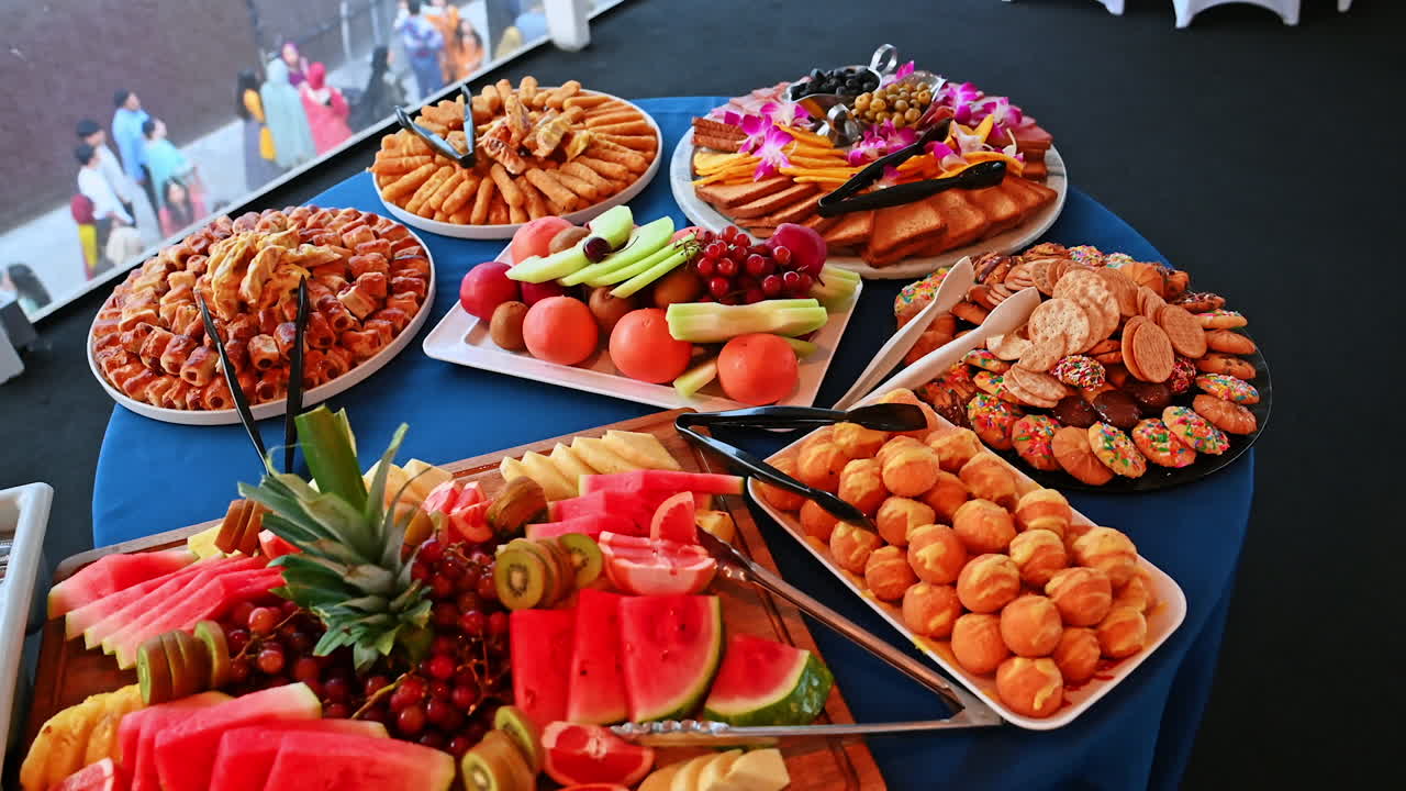 Buffet table with fruits, pastries and cheese platters. Colorful buffet with sliced fruits, pastries, cheese and cold cuts