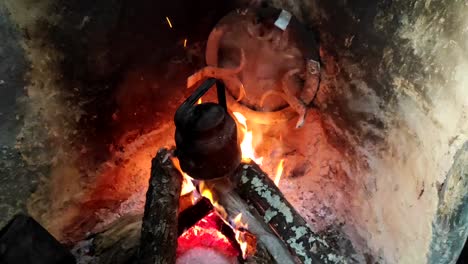 primer plano de cocinar la cena en una olla sobre un fuego de madera en una chimenea de ladrillo en una cocina tradicional-3