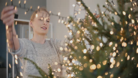 donna che decora l'albero di natale a casa