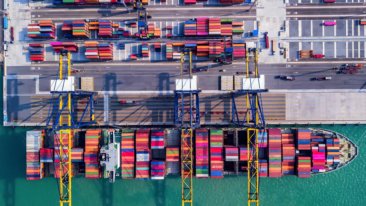 Ovenfra time-lapse af losning af varer fra skibet i industrihavn med containerhavn, som er en del af skibsfarten