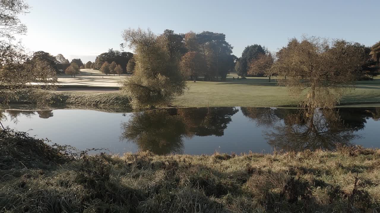 Stagno calmo riflette il Waterford Golf Resort brinato in una fresca mattinata di sole