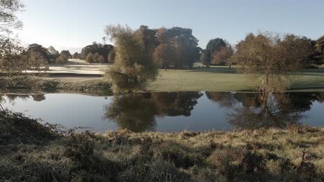 Der-Ruhige-Teich-Spiegelt-Das-Frostige-Waterford-Golf-Resort-An-Einem-Kühlen,-Sonnigen-Morgen-Wider