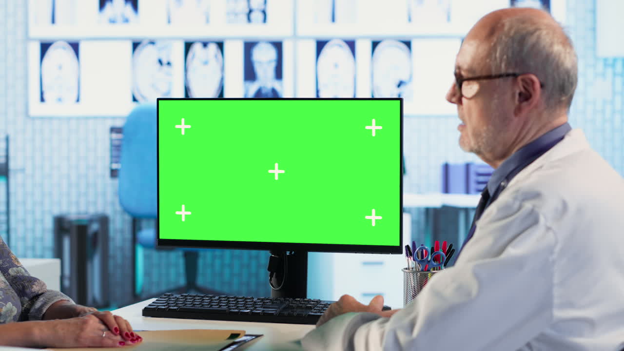 Experienced physician doing check up routine with patient next to chroma key