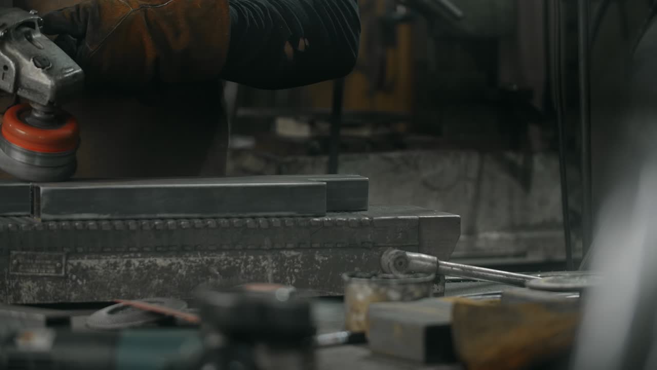 металлург чистит сталь электрической круговой металлической щеткой, металлургия в кузнечной мастерской, 4k 60p prores hq